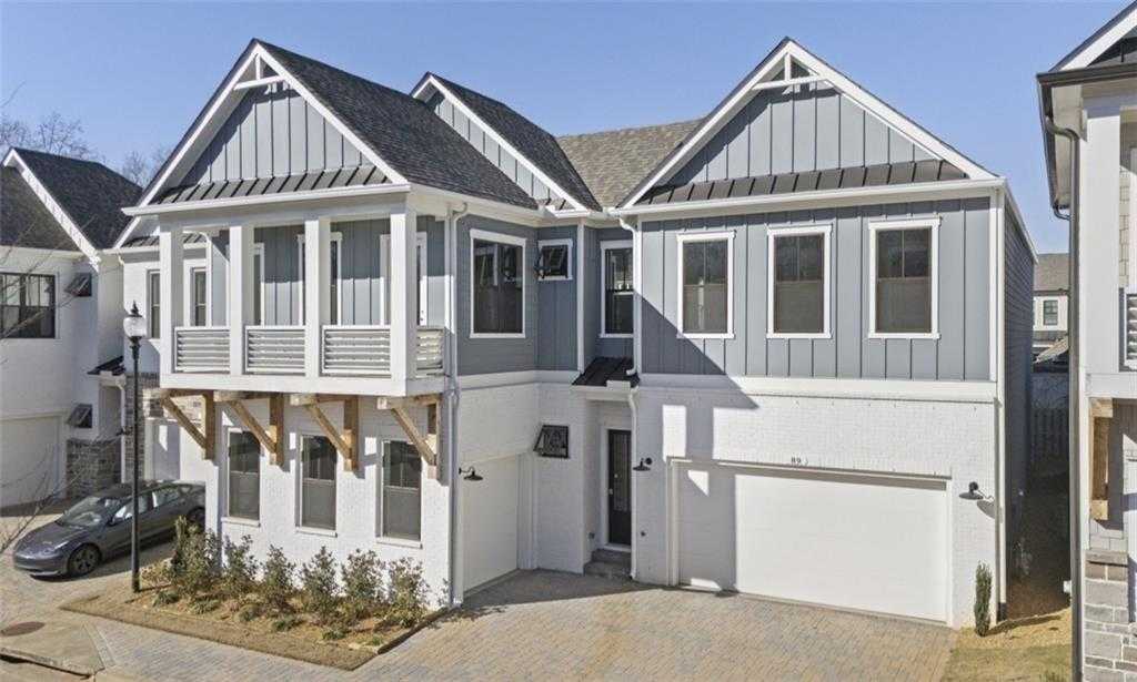 Modern two-story Seaside A home by Davidson Homes featuring gray siding, balconies, 3-car garage in The Village at Towne Lake, Woodstock, GA
