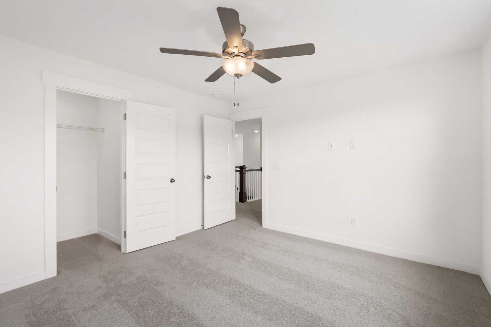 Spacious carpeted bedroom with ceiling fan, closet, and hallway access in The Willow D, Benders Cove, Mt. Juliet