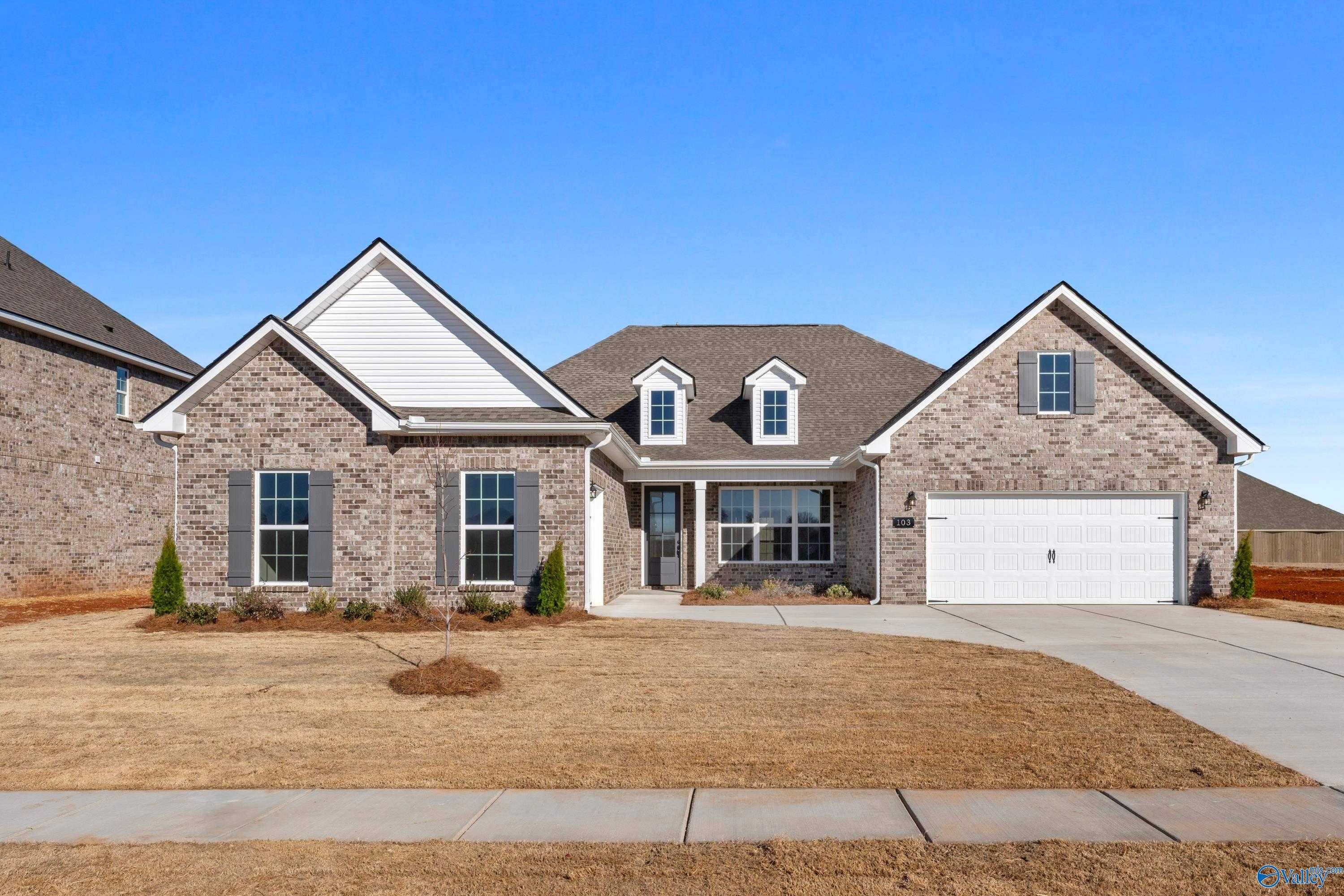 Single-story brick Valencia home by Davidson Homes with 3-car garage, white trim, and front landscaping in Briercreek, Meridianville, Alabama