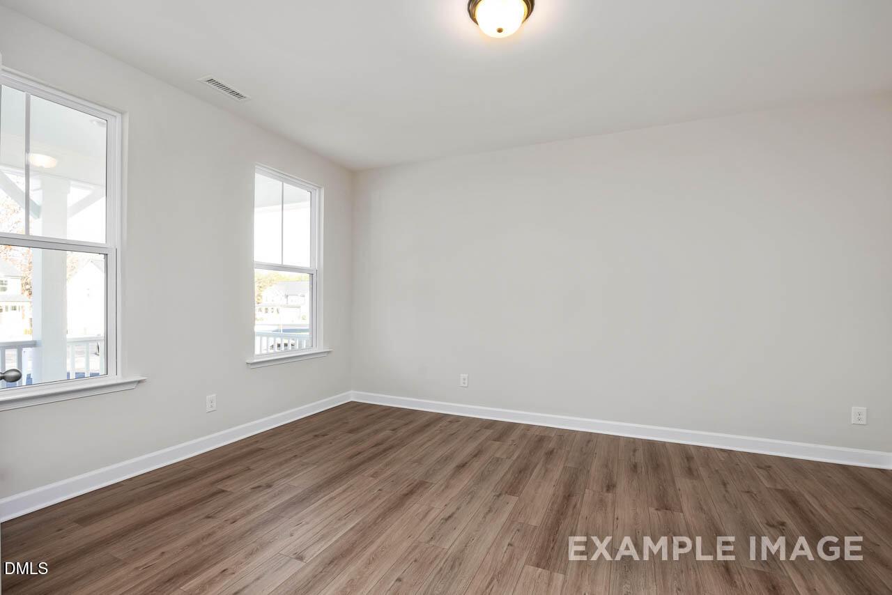 Bright, spacious bedroom with wood-style flooring in The Hickory II B floor plan by Davidson Homes in Montrose, Aberdeen.