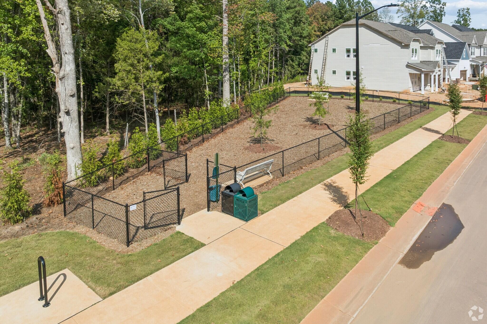 Fenced community dog park with benches and waste stations at Sage on North Main in Wake Forest, NC by Davidson Homes