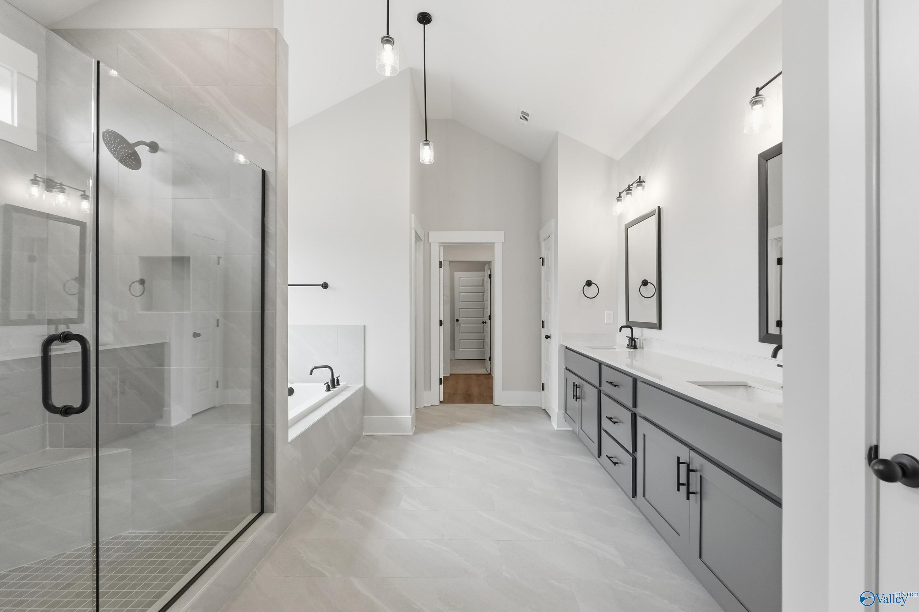 Elegant master bathroom with frameless glass shower, freestanding tub, and dual gray vanities in Davidson Homes The Finleigh, Meridianville AL