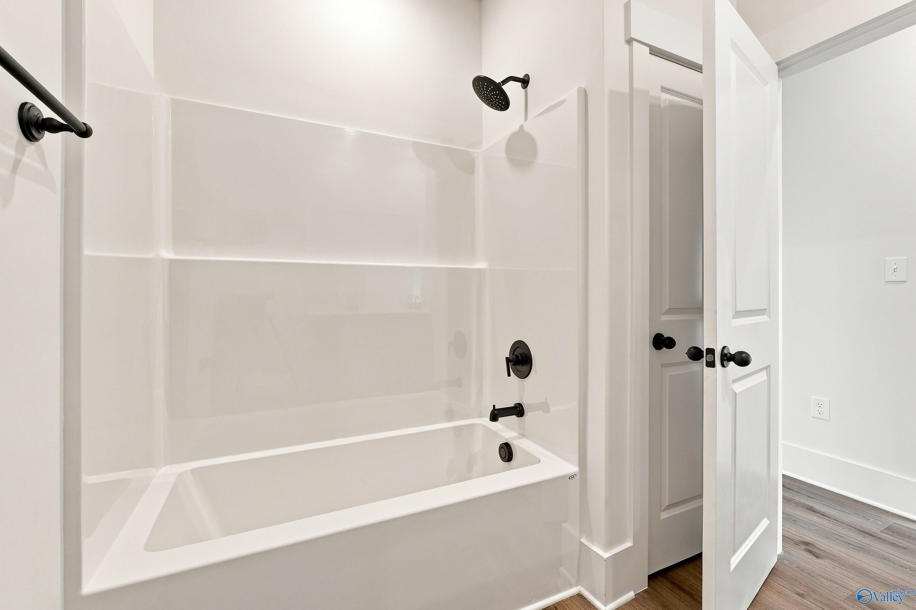 White tub-shower combo with matte black fixtures in bathroom of Davidson Homes The Valencia, Riverton Preserve, Huntsville, AL