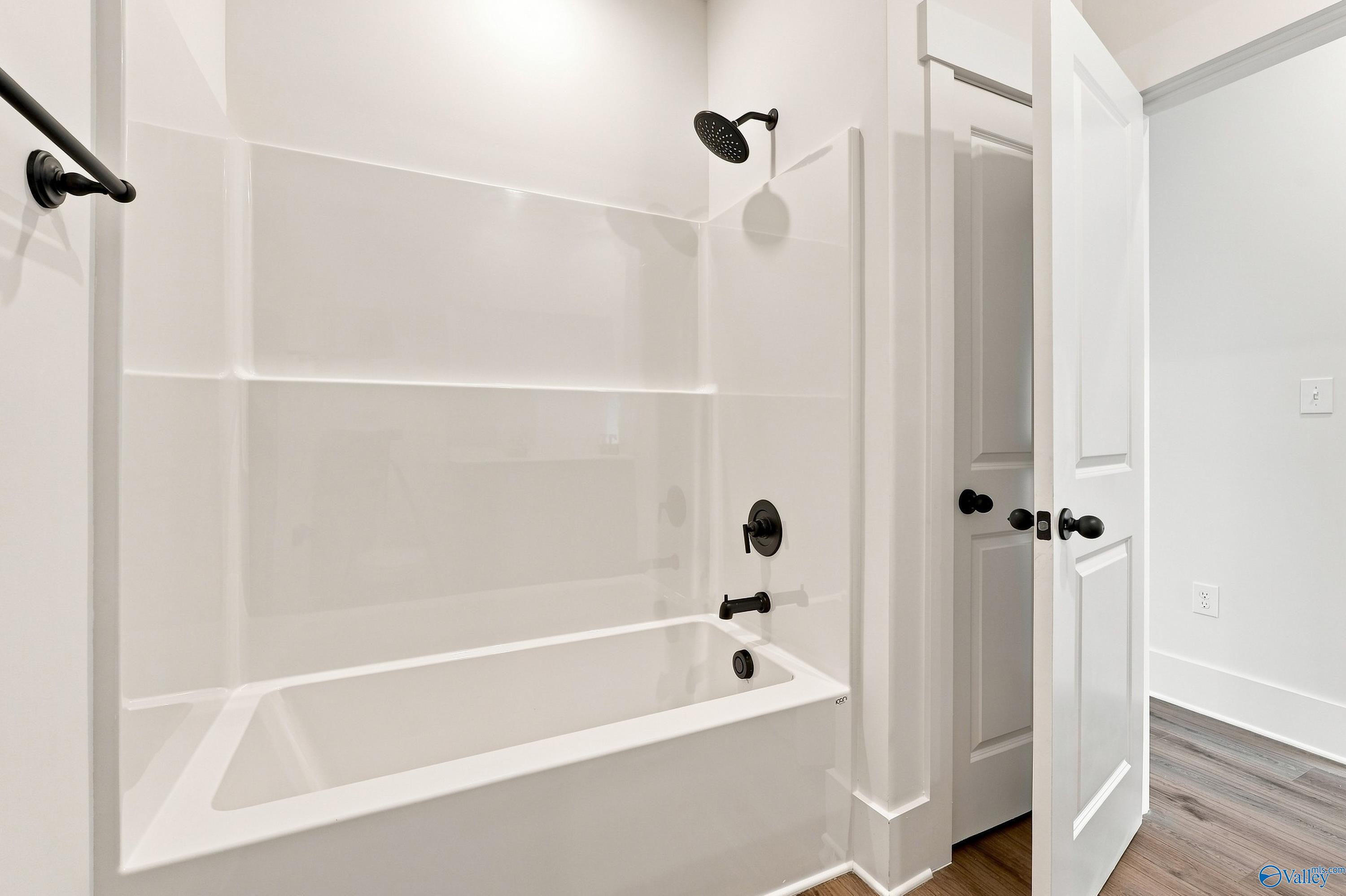 White tub-shower combo with matte black fixtures in bathroom of Davidson Homes The Valencia, Riverton Preserve, Huntsville, AL