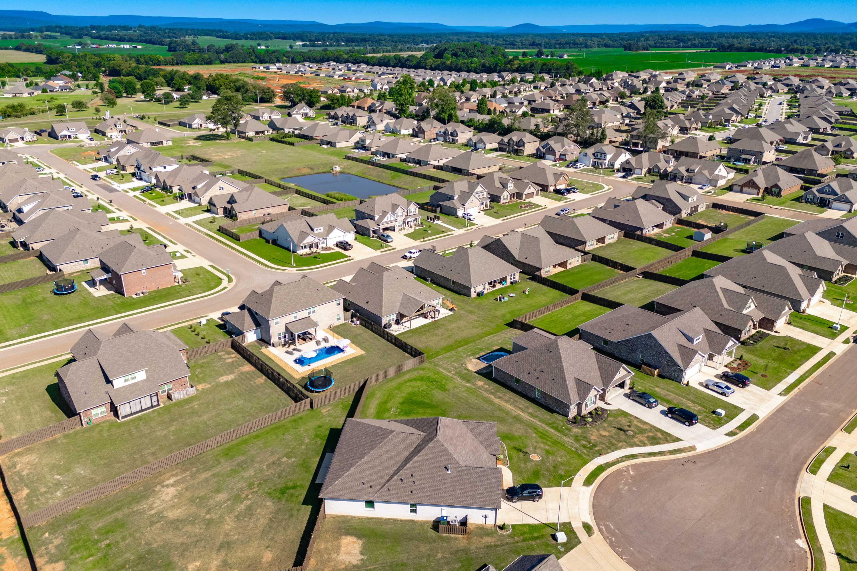 Aerial view of Pikes Ridge neighborhood in Meridianville, AL featuring modern single-family homes, community pool, and green lawns by Davidson Homes