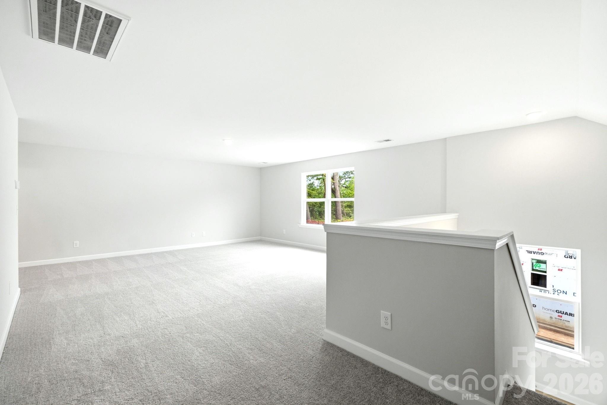Spacious carpeted loft area in The Magnolia B floor plan at Windgate in Mooresville, North Carolina.