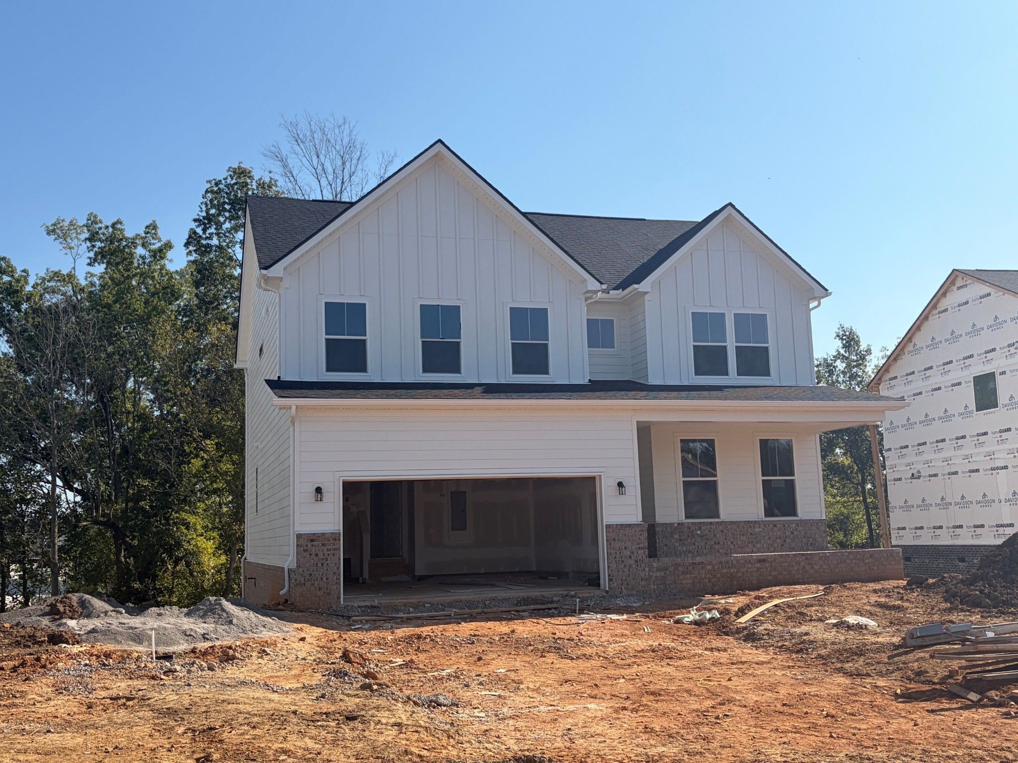 Two-story white farmhouse-style new construction home with 2-car garage under construction at Calista Farms, White House, TN by Davidson Homes