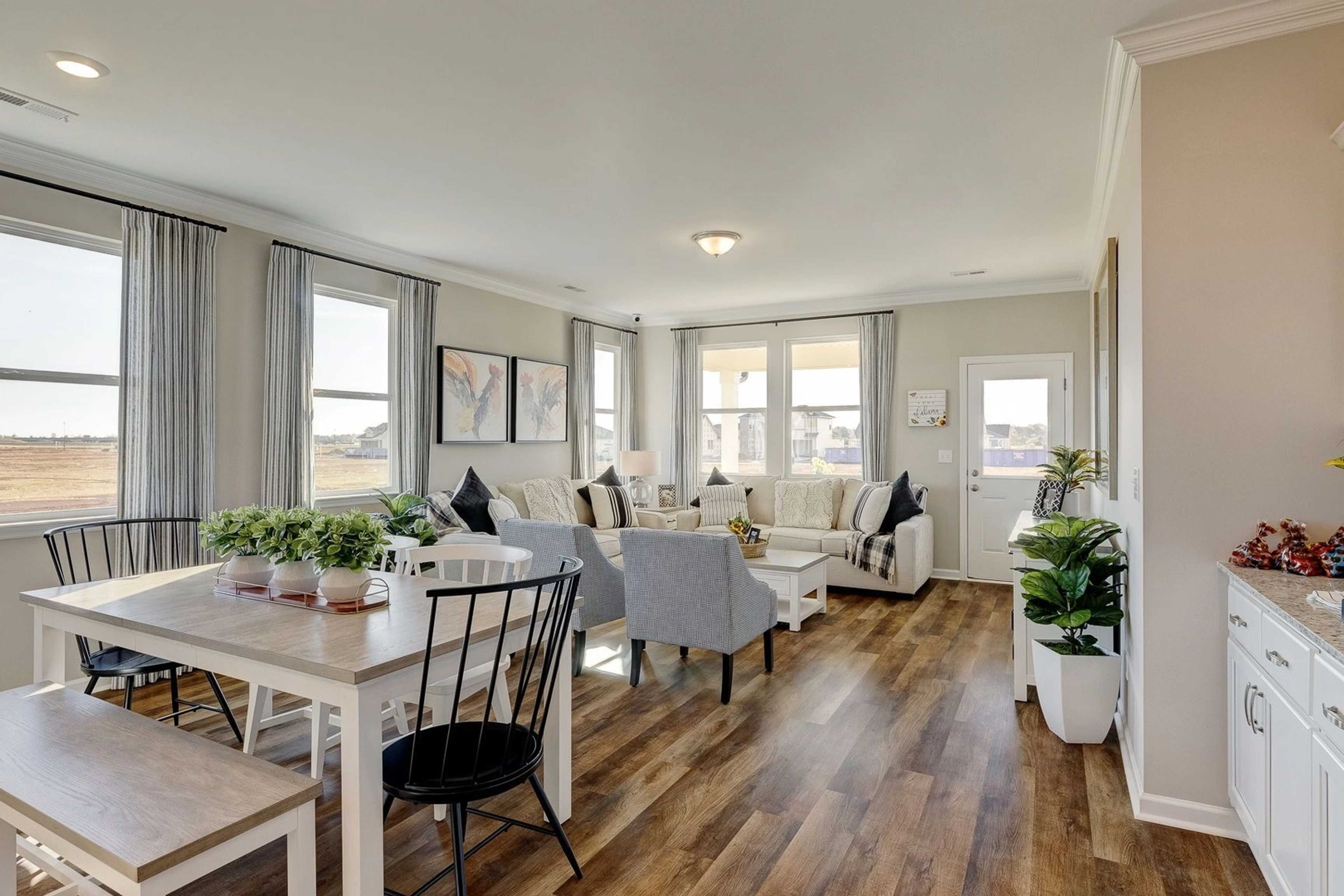 Spacious open-concept kitchen and living area in Carroll Green, Harvest Alabama with hardwood floors and white cabinetry