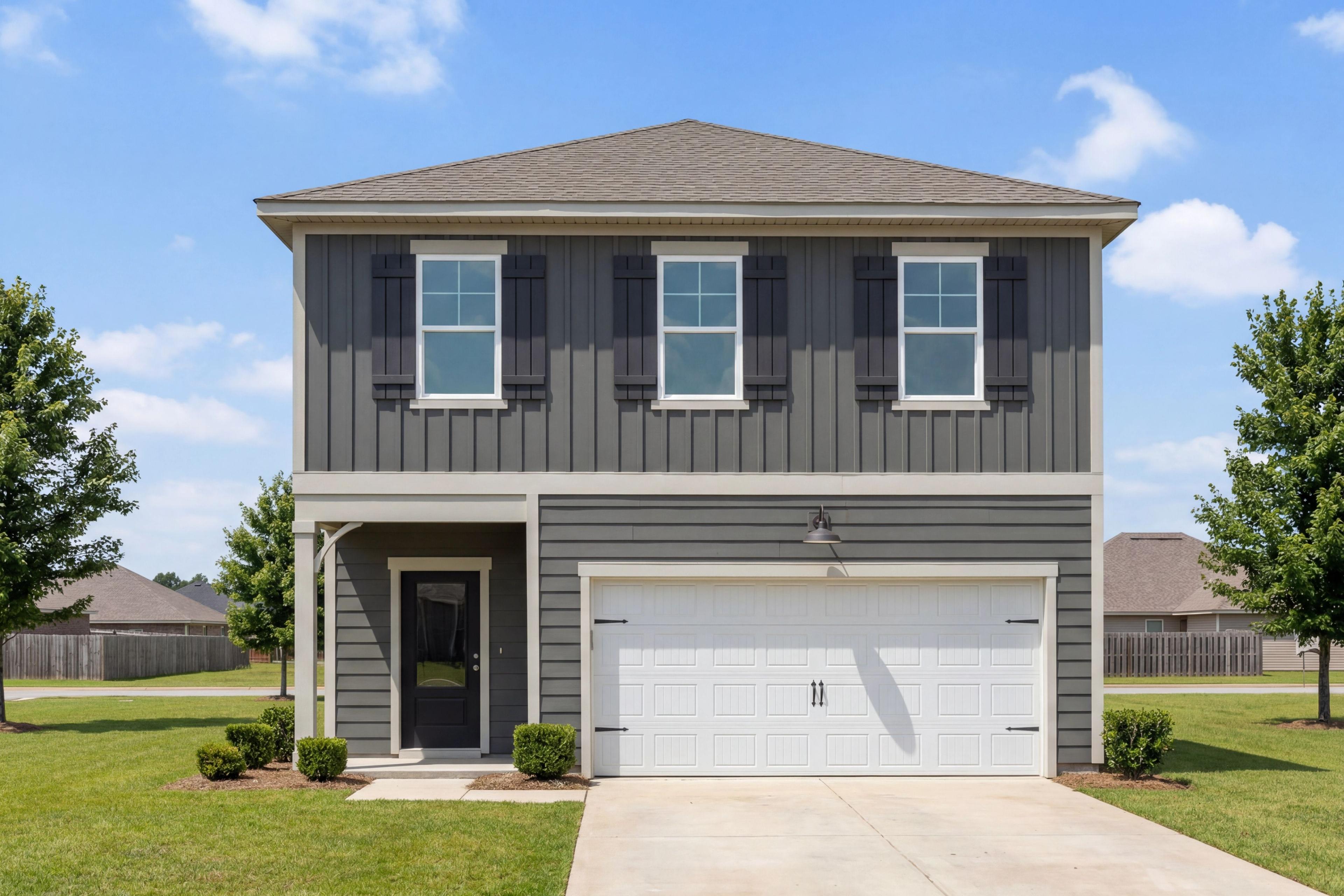 Two-story exterior of The Burton B home design in Cullman, Alabama featuring dark gray siding and a two-car garage.
