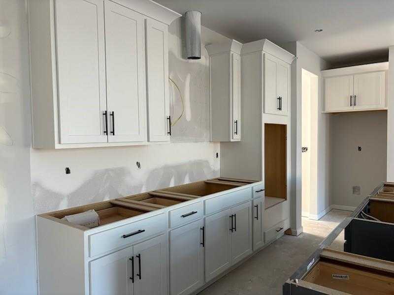 Modern white shaker kitchen cabinets with stainless vent hood in Davidson Homes Cary C floor plan, Winder, Georgia