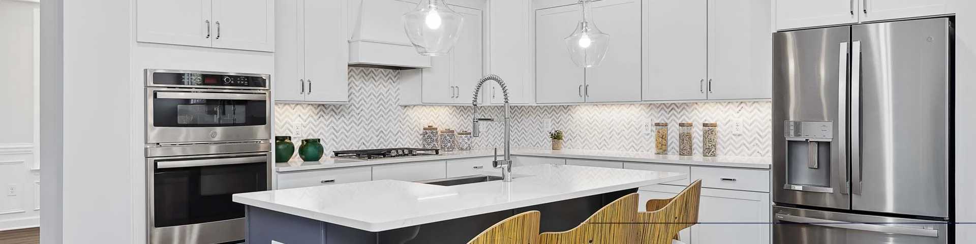 Spacious modern kitchen in new Wendell home with white cabinets, blue island, stainless steel appliances