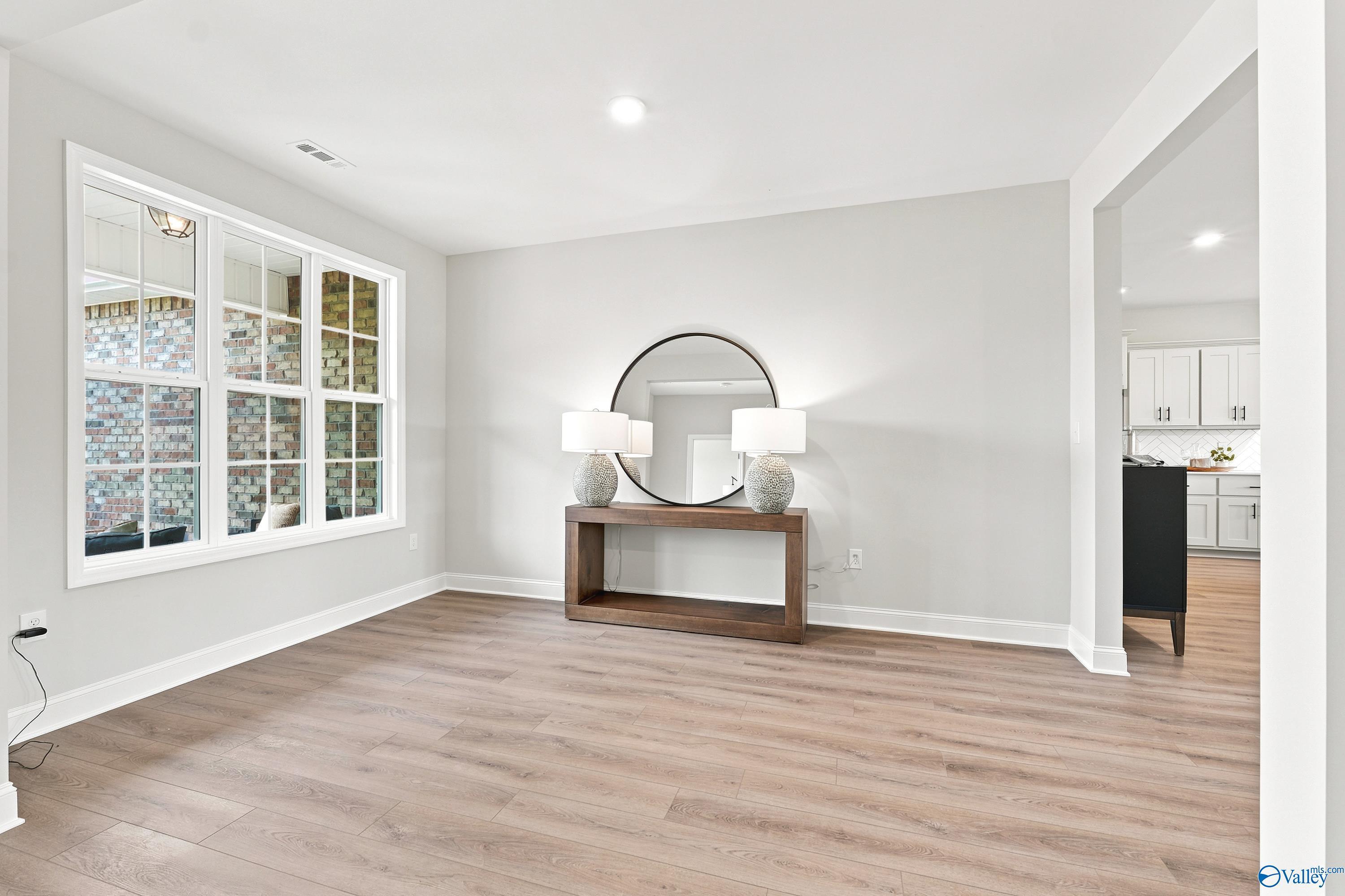 Bright dining room with wood-look flooring and console table in The Finleigh floor plan at Riverton Preserve, Huntsville.