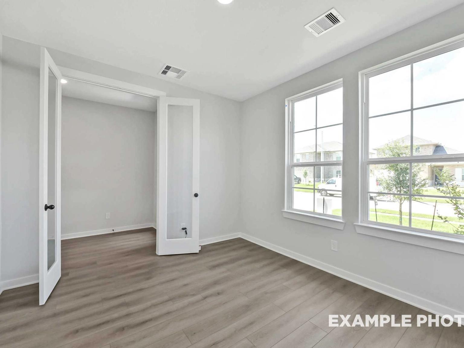 Bright home office or flex room with French doors and wood-look flooring in The Sequoia C at Sundance Cove, Crosby, TX.