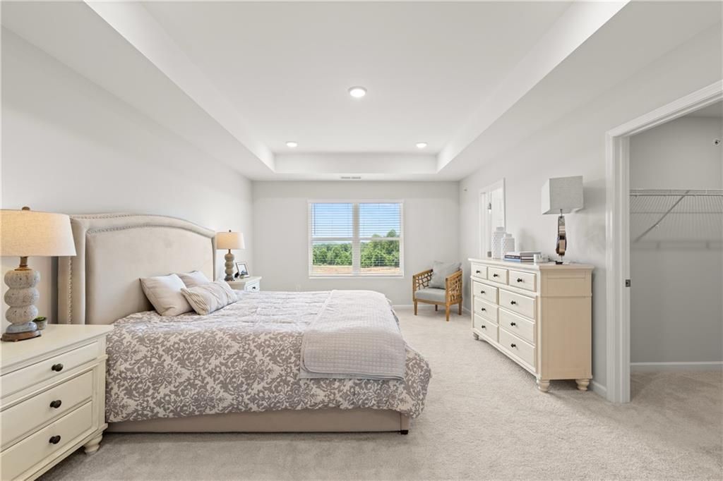 Primary bedroom with tray ceiling and walk-in closet in The Wake B floor plan by Davidson Homes in Hemingway, Cumming, GA.
