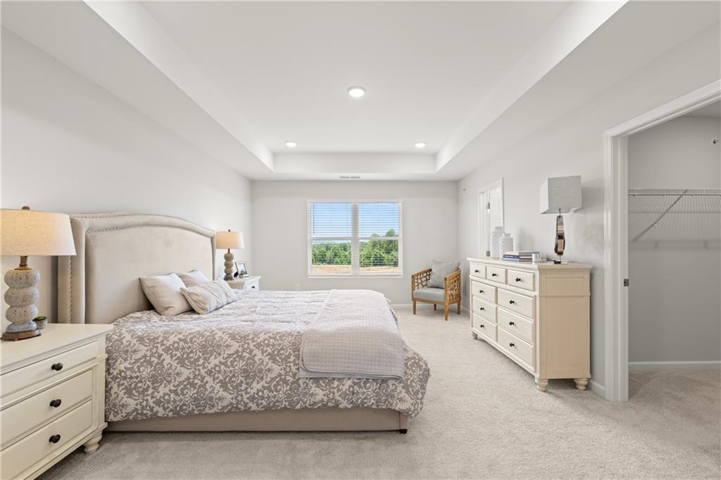 Primary bedroom with tray ceiling and walk-in closet in The Wake B floor plan by Davidson Homes in Hemingway, Cumming, GA.