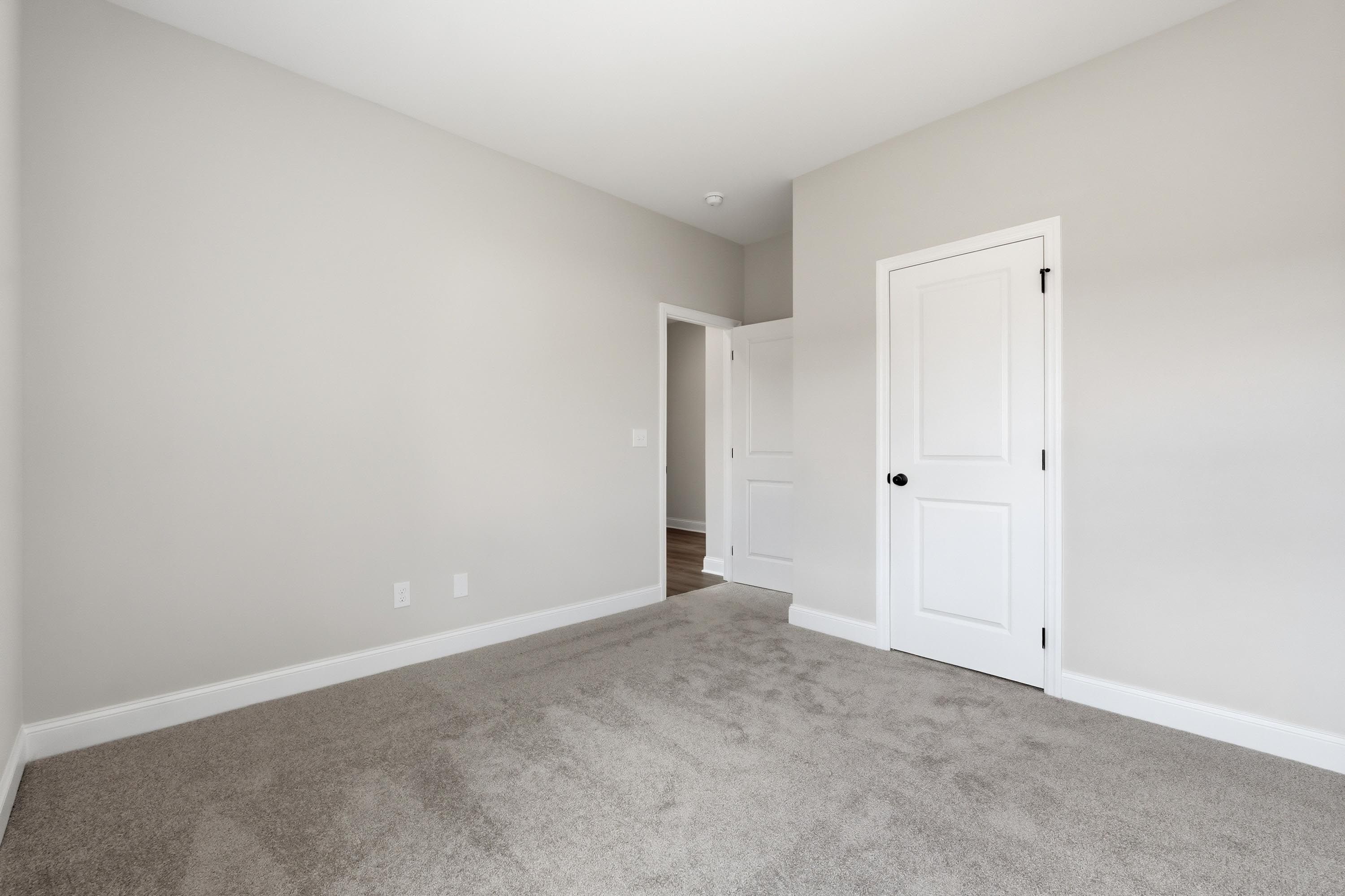 Spacious carpeted bedroom in The Glen A floor plan featuring neutral paint and white interior doors.