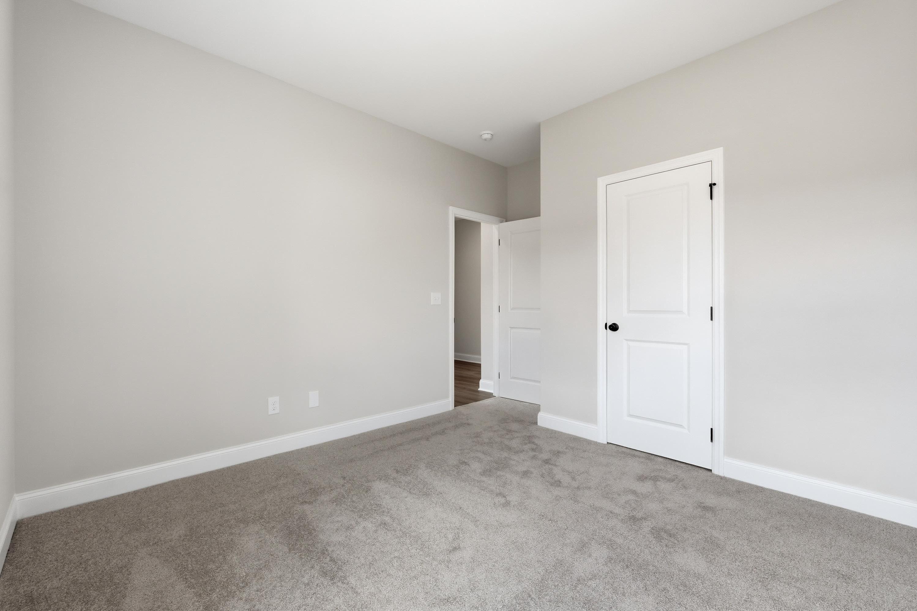 Spacious carpeted bedroom in The Glen A floor plan featuring neutral paint and white interior doors.