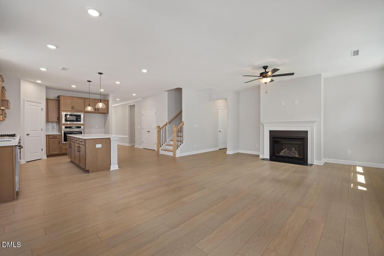 Open-concept living room and kitchen with fireplace in Ashport L floor plan at Sage on North Main, Wake Forest, NC.