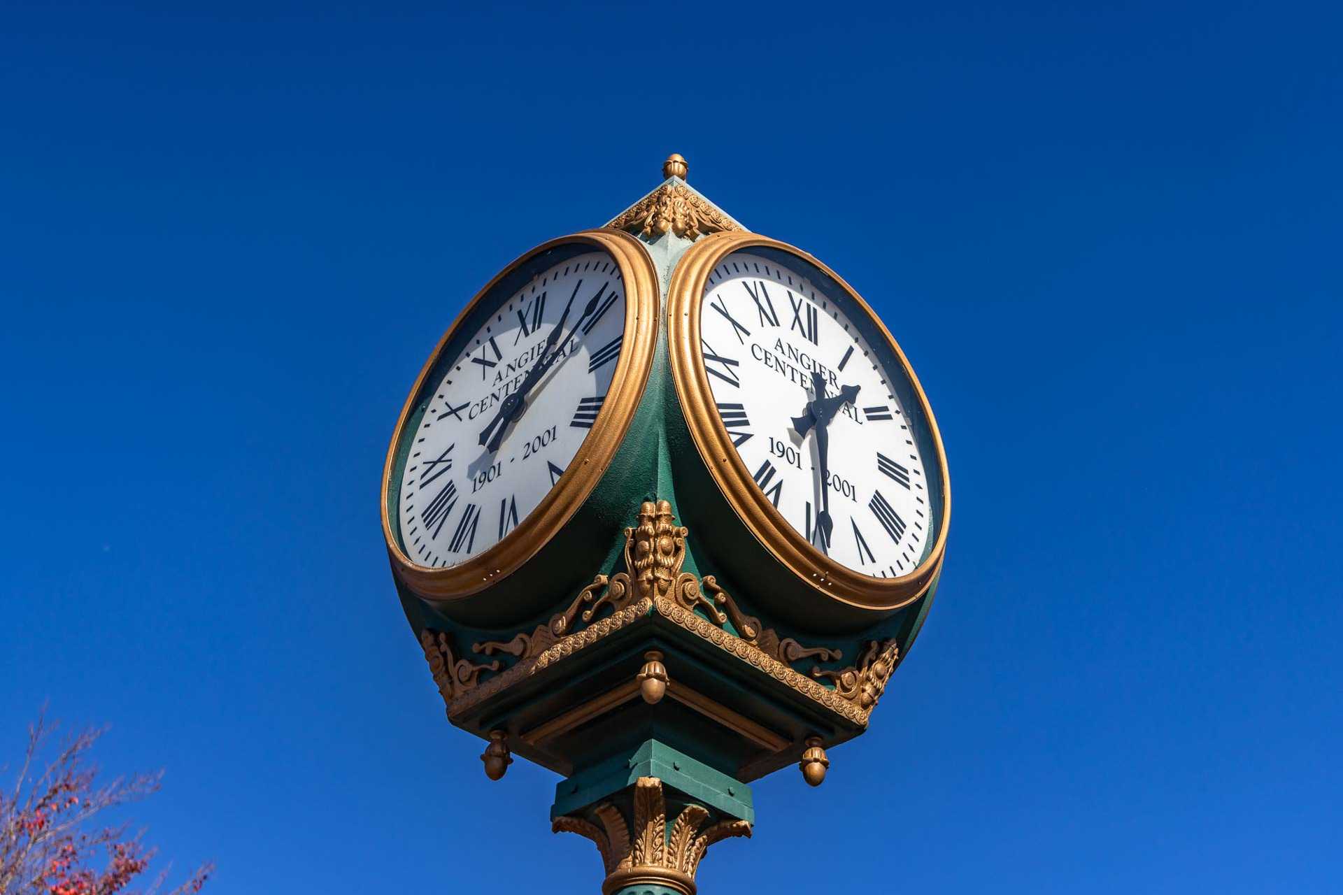Ornate green clock pedestal with gold accents and Roman numeral faces at Weatherford East in Angier, NC