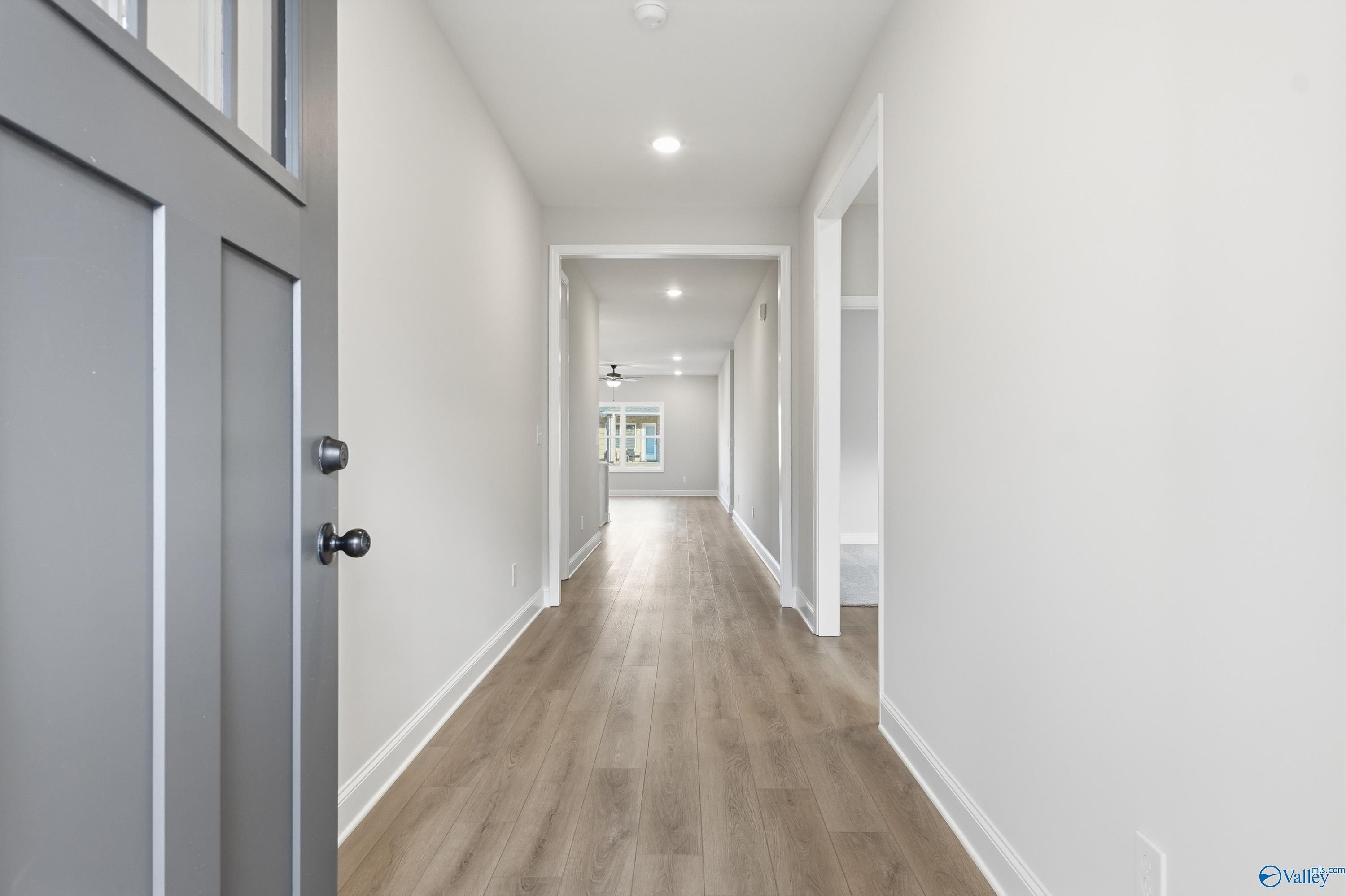 Spacious entry hallway with light wood floors, white walls, and recessed lighting in The Daphne D 4-bedroom home, Arab, Alabama