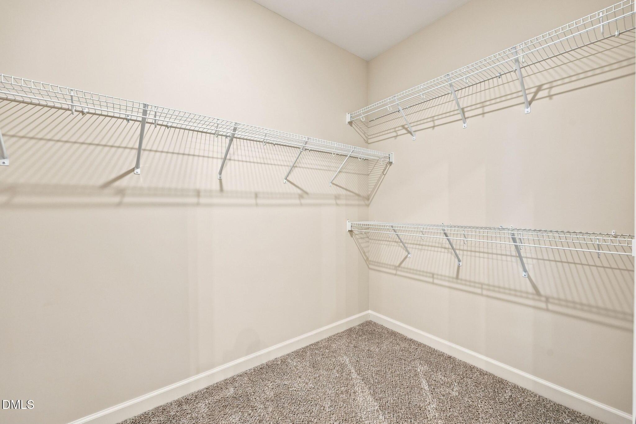 Spacious walk-in closet with wire shelving in The Magnolia B floor plan at Retreat at North Main, Lillington, NC.