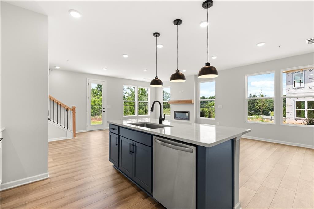 Modern kitchen island with pendant lighting and open-concept living in The Durham D floor plan at Hemingway, Cumming, GA.