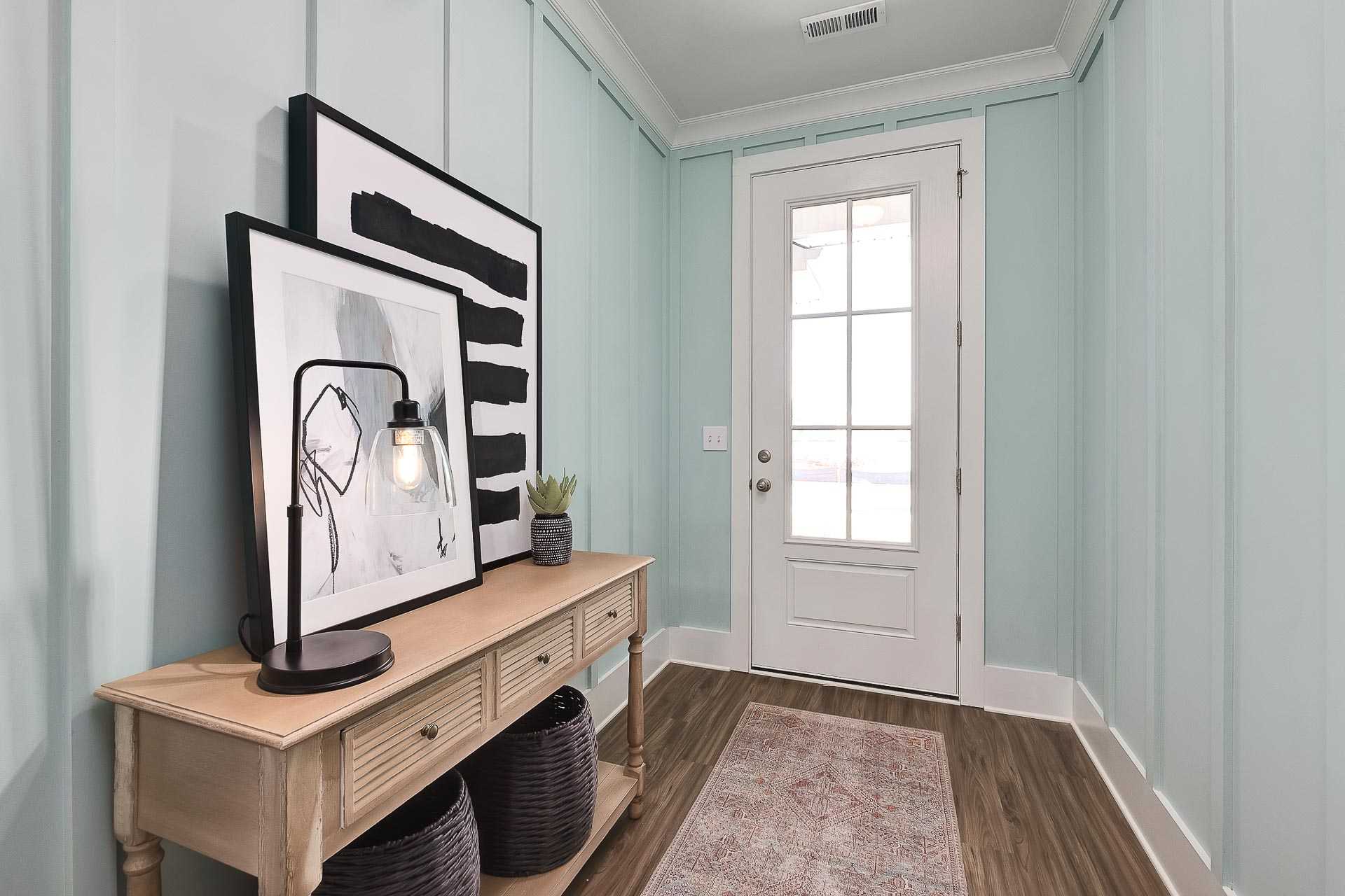 Coastal entryway in Newby Chapel Athens AL home with mint shiplap walls, oak console table, abstract art, and French door