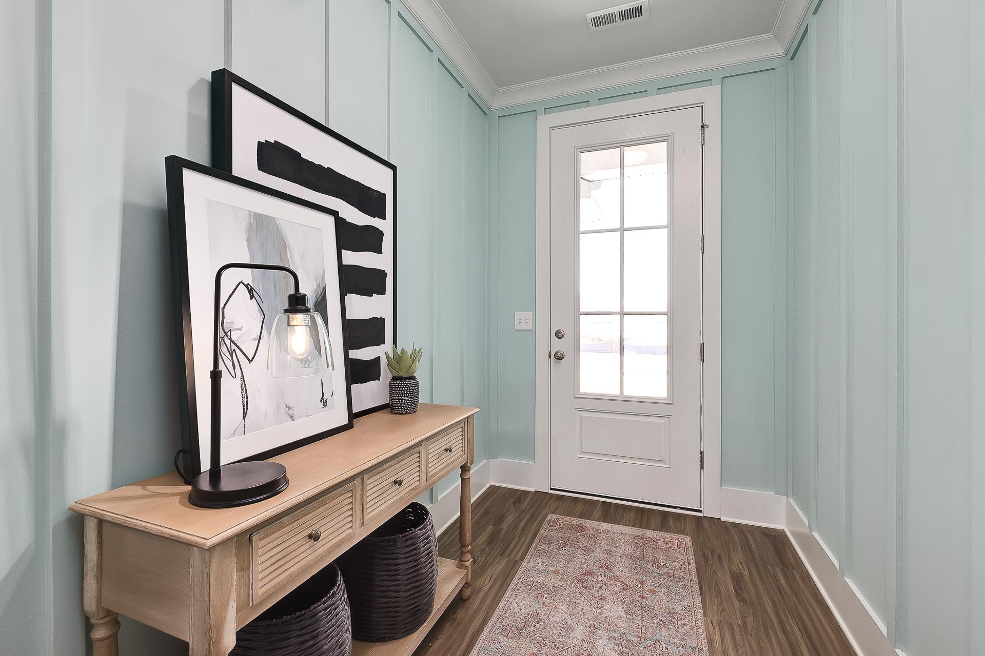 Coastal entryway in Newby Chapel Athens AL home with mint shiplap walls, oak console table, abstract art, and French door