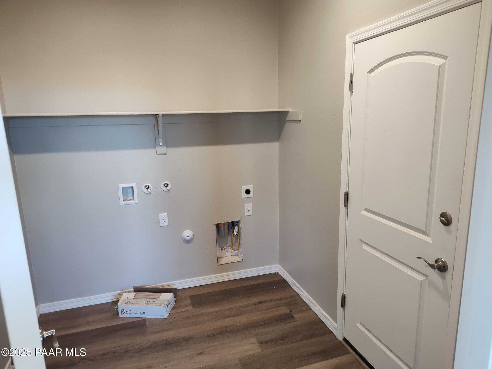 Modern laundry room with washer dryer hookups, open shelving, and neutral walls in Davidson Homes The Frontier A, Prescott Valley, Arizona