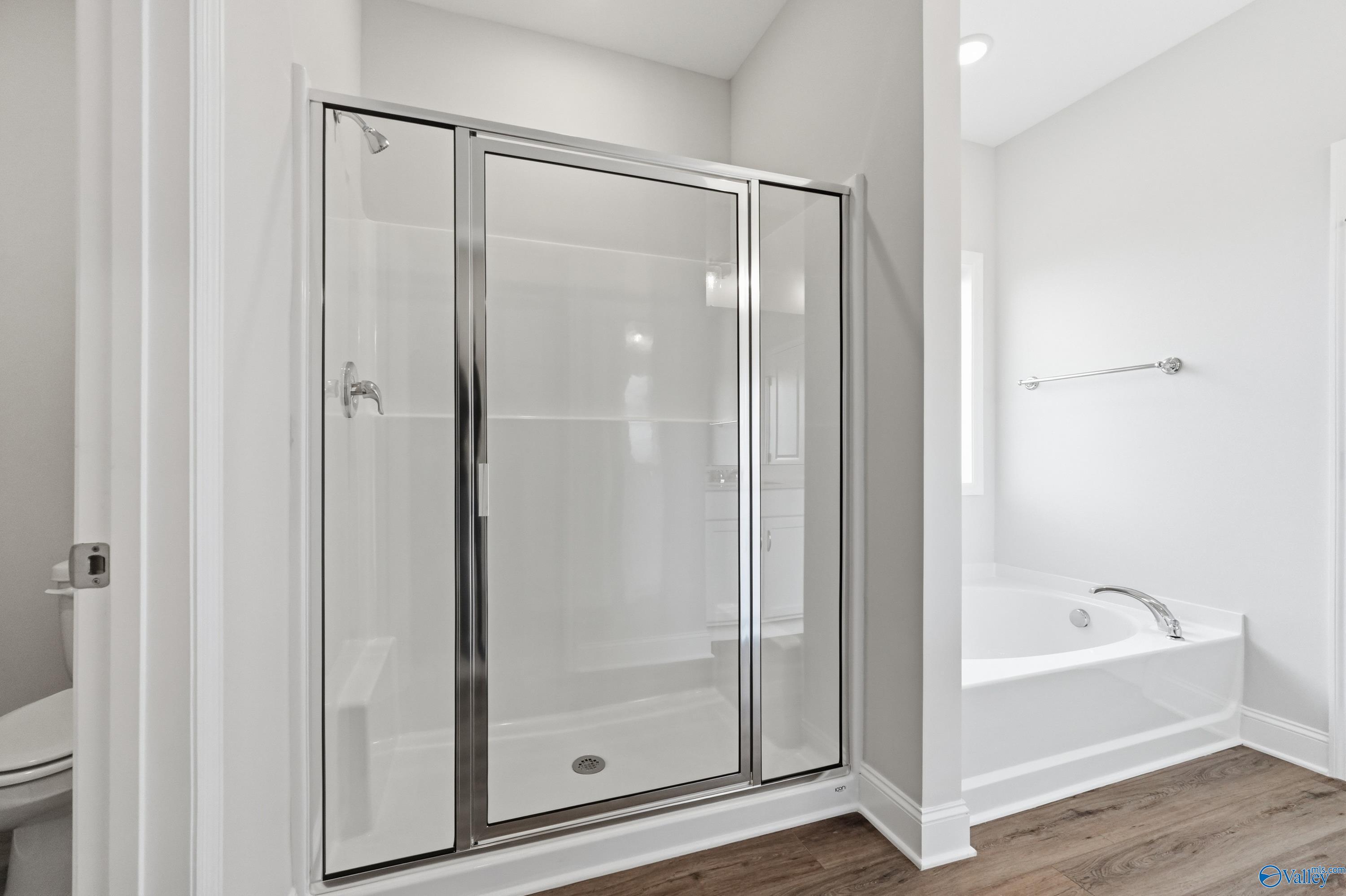 Modern master bathroom featuring frameless glass walk-in shower and soaking tub in Davidson Homes The Daphne C, Toney, Alabama