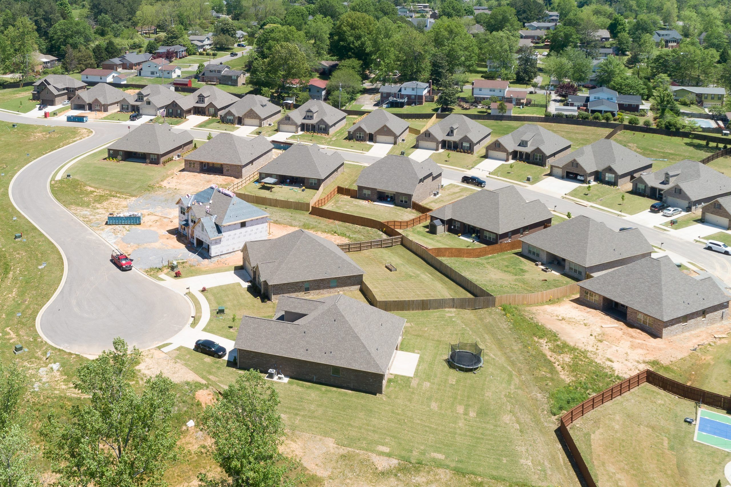 Aerial view of new single-family homes in Stone Creek Phase II, Cullman Alabama by Davidson Homes with curved roads and wooded lots