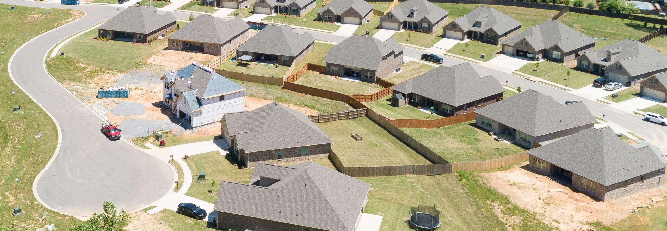 Aerial view of new single-family homes in Stone Creek Phase II, Cullman Alabama by Davidson Homes with curved roads and wooded lots
