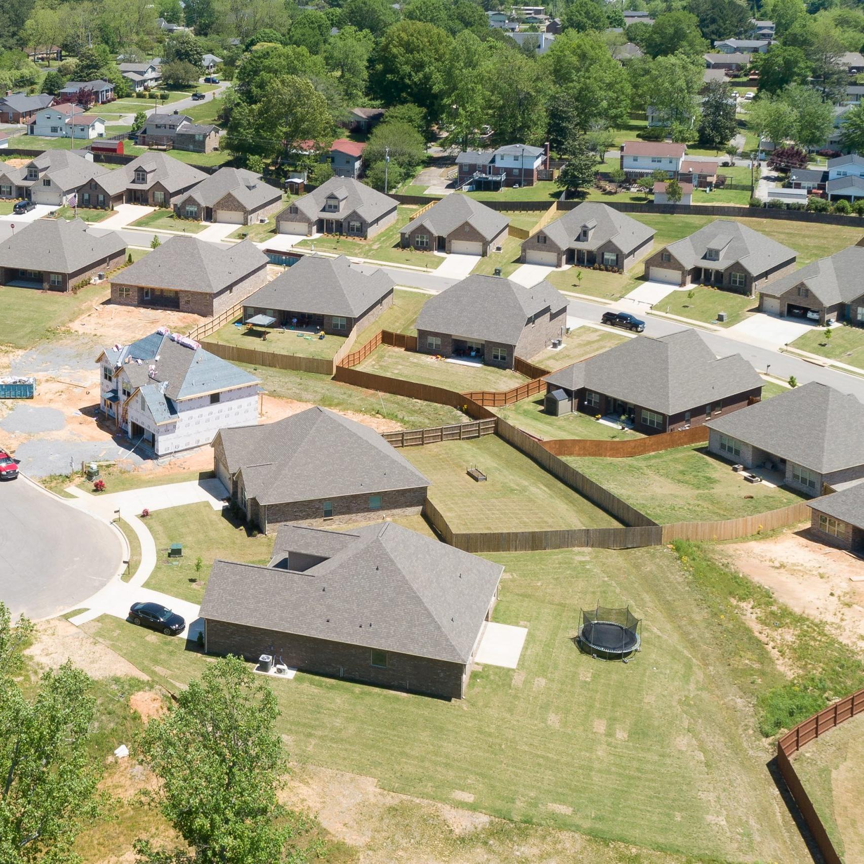 Aerial view of new single-family homes in Stone Creek Phase II, Cullman Alabama by Davidson Homes with curved roads and wooded lots