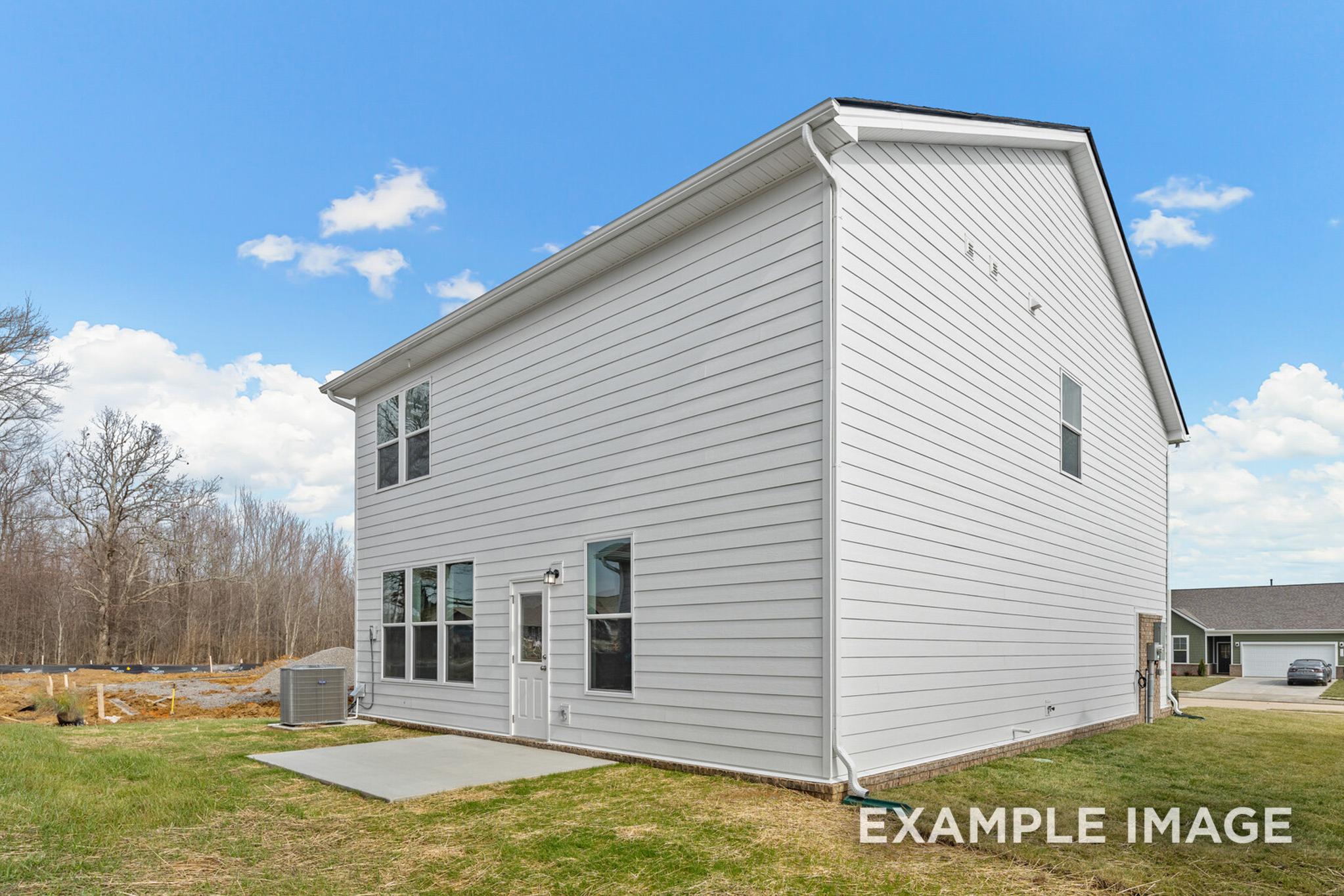 Two-story The Logan C home exterior featuring white siding, side-entry garage, multi-pane windows, and new lawn in White House, TN