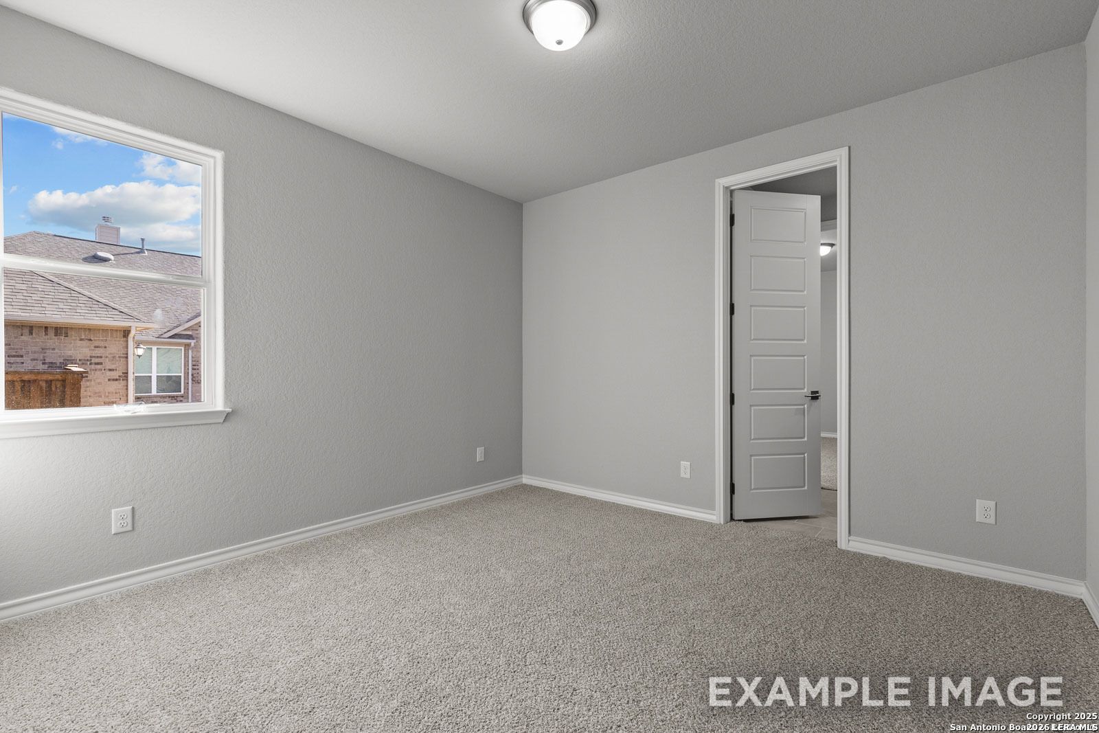 Spacious carpeted bedroom with neutral gray walls in Davidson Homes Oxford F floor plan, Potranco Oaks, Castroville, Texas.