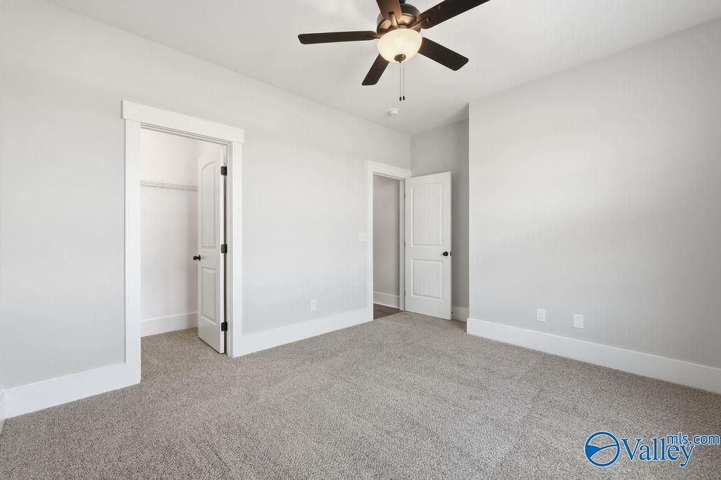 Spacious bedroom with ceiling fan, walk-in closet, and adjacent bath in Davidson Homes The Rockford, Hartselle, Alabama