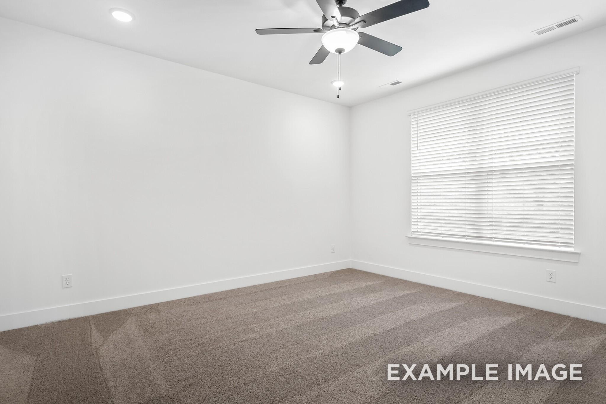 Bright empty bedroom with white walls, beige carpet, ceiling fan, and large window in Davidson Homes Ridgeport C, Gallatin, Tennessee