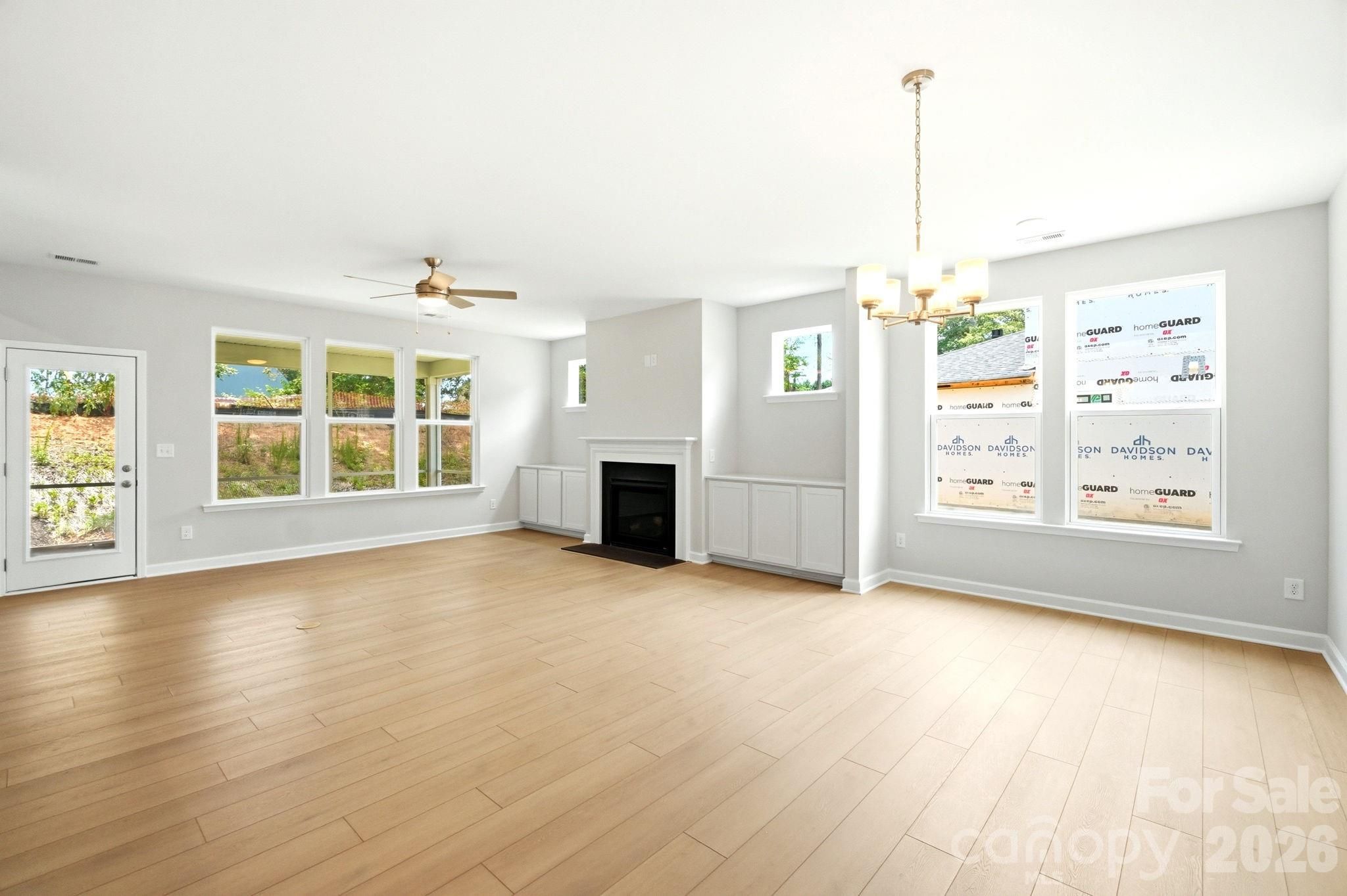 Spacious living room with fireplace and light wood floors in The Magnolia B floor plan at Windgate, Mooresville, NC.