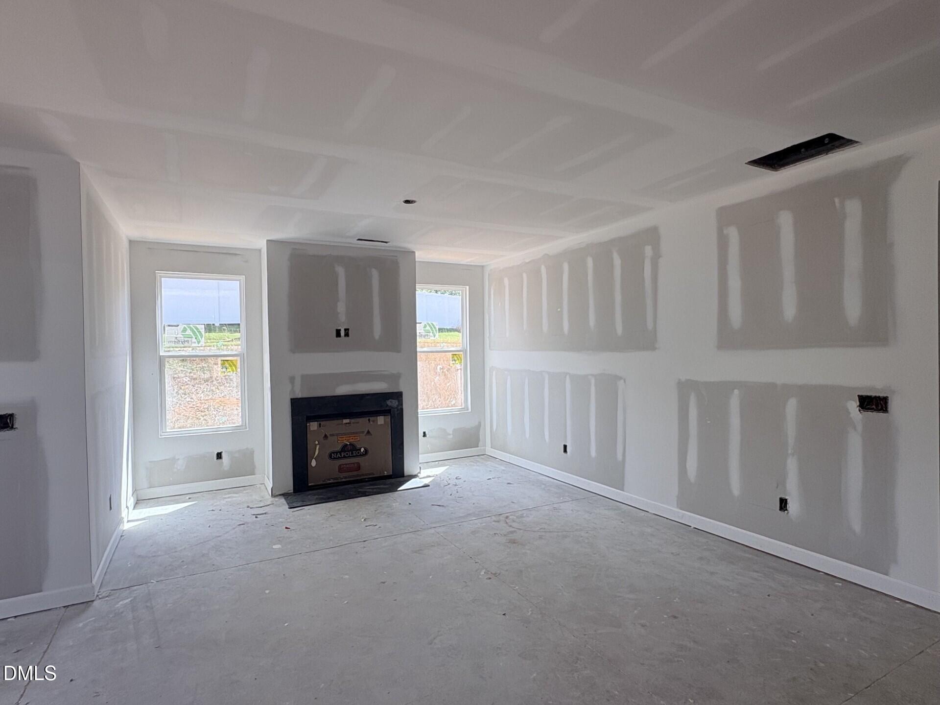 Unfinished living room with fireplace in The Ash C floor plan by Davidson Homes at Woodland Crossing in Zebulon, NC.