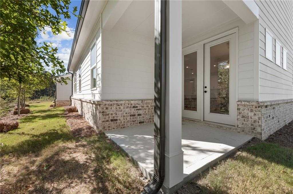 Covered back patio with French doors on white brick-accented home exterior, Davidson Homes The Daphne B, Kelly Preserve, Loganville, Georgia