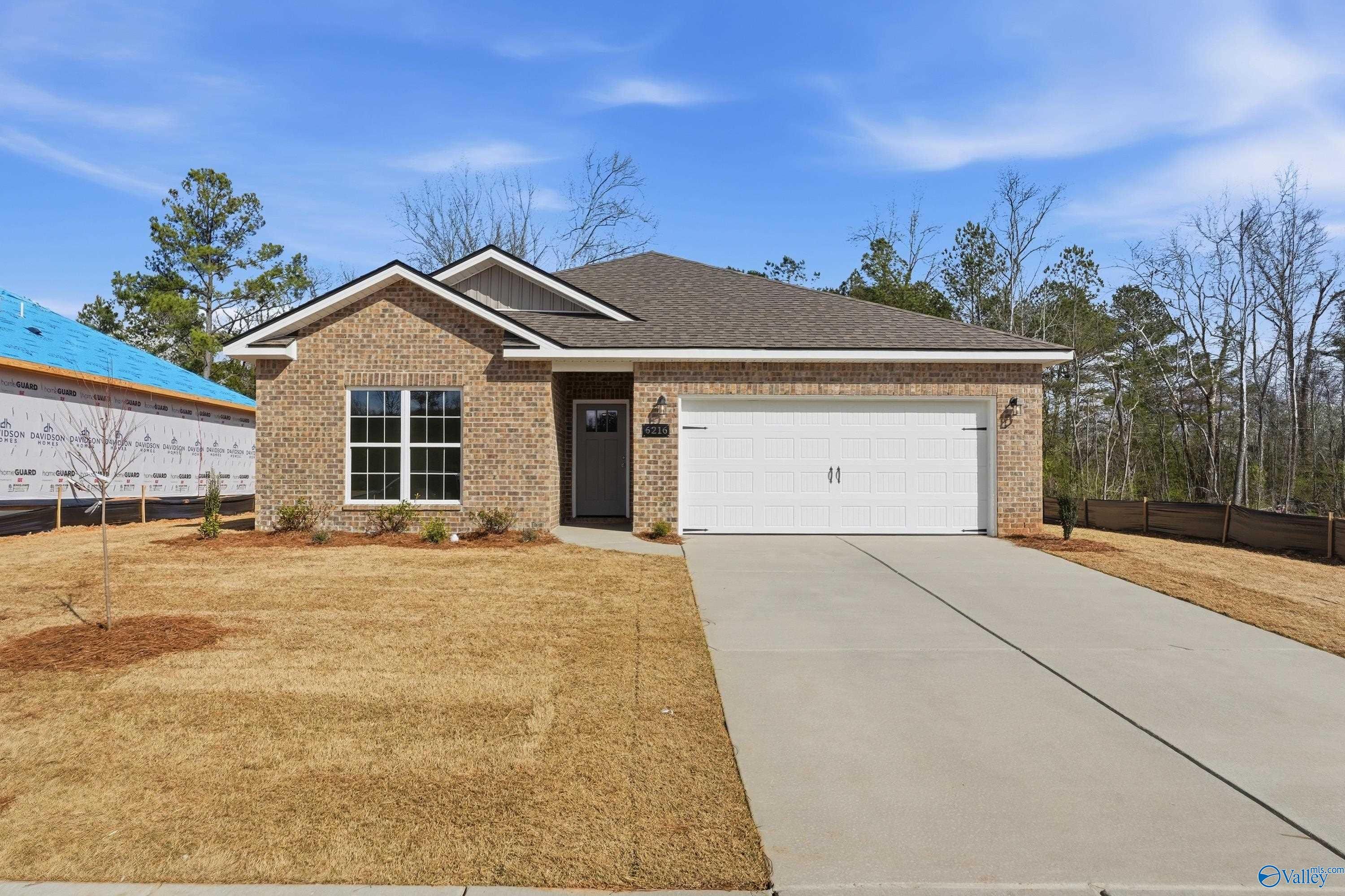 Modern brick single-story home with 2-car garage, driveway, and pine trees in Spragins Cove, Huntsville, Alabama - Davidson Homes The Asheville