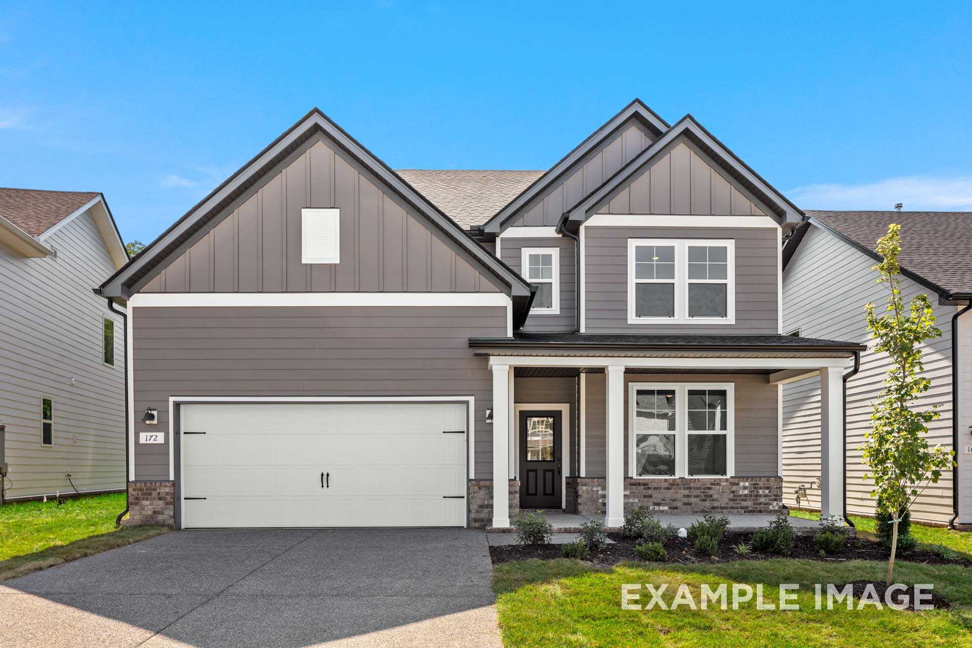 Two-story The Henry B craftsman home elevation with gray siding, covered porch, two-car garage, and landscaped yard in Mt. Juliet, TN