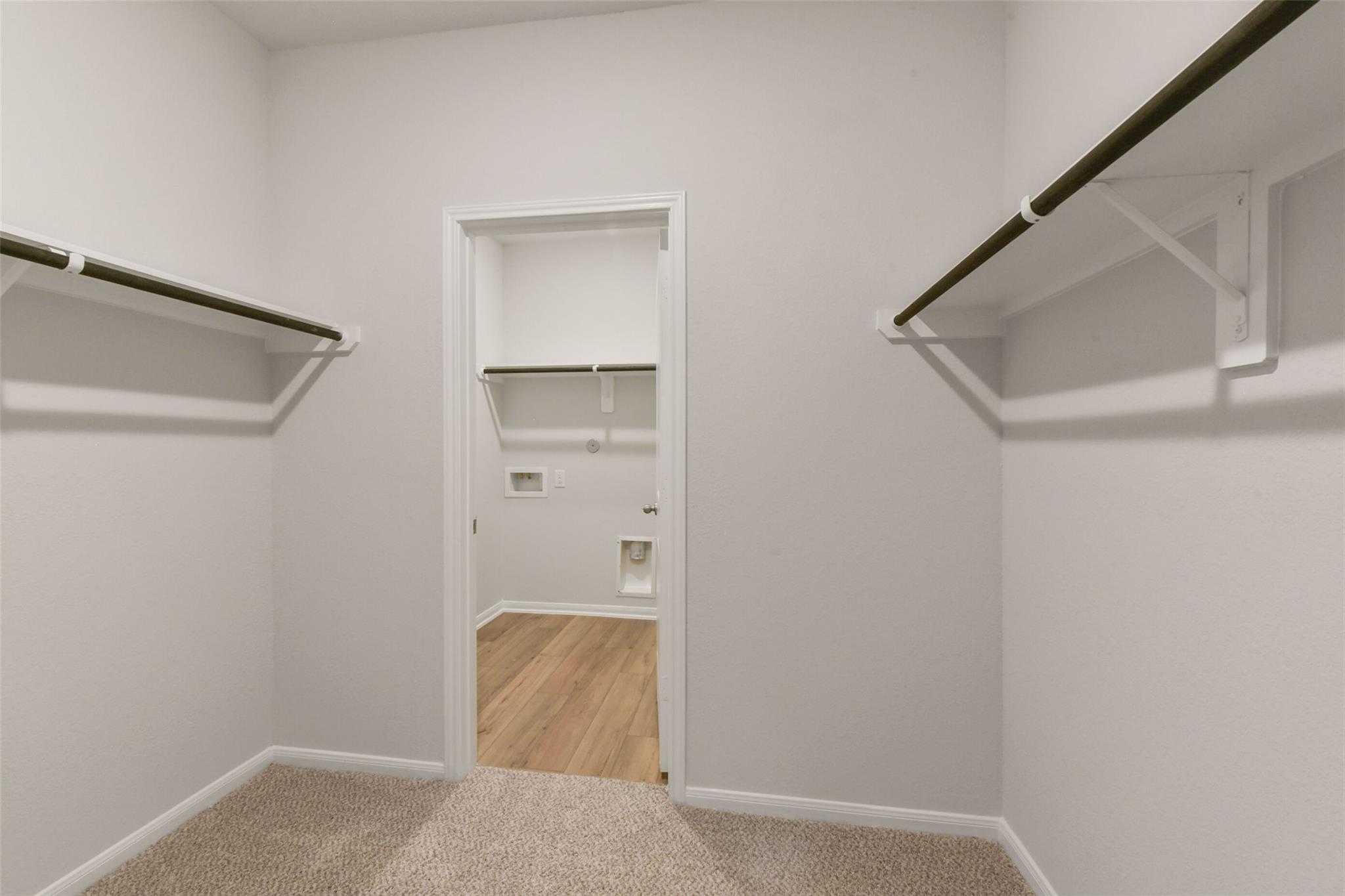 Spacious walk-in closet with dual shelving and hanging rods in Davidson Homes The Laguna B, Magnolia, Texas