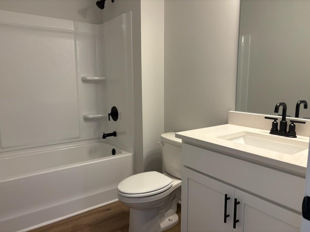 Bright white secondary bathroom with tub, tiled shower, single vanity and toilet in Davidson Homes The Hickory B, Winder, Georgia