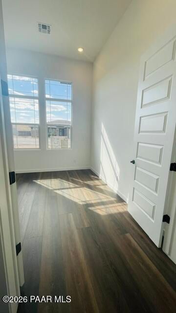 Bright bedroom with wood-look flooring and large windows in The Aurea C floor plan at Hidden Hills, Prescott, Arizona.