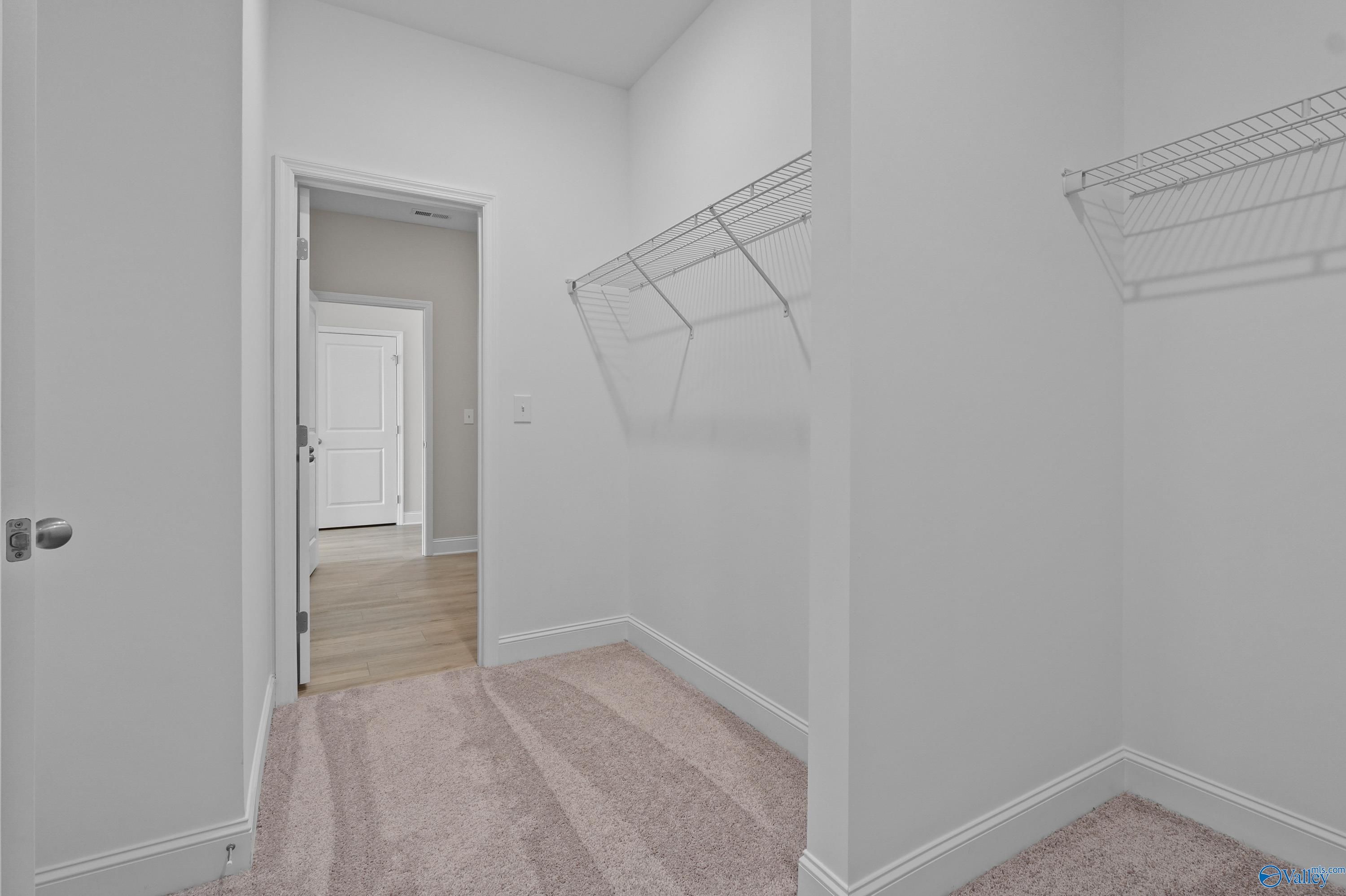 Spacious walk-in closet with wire shelving and open door to bedroom in Davidson Homes The Everett, Hazel Green, Alabama
