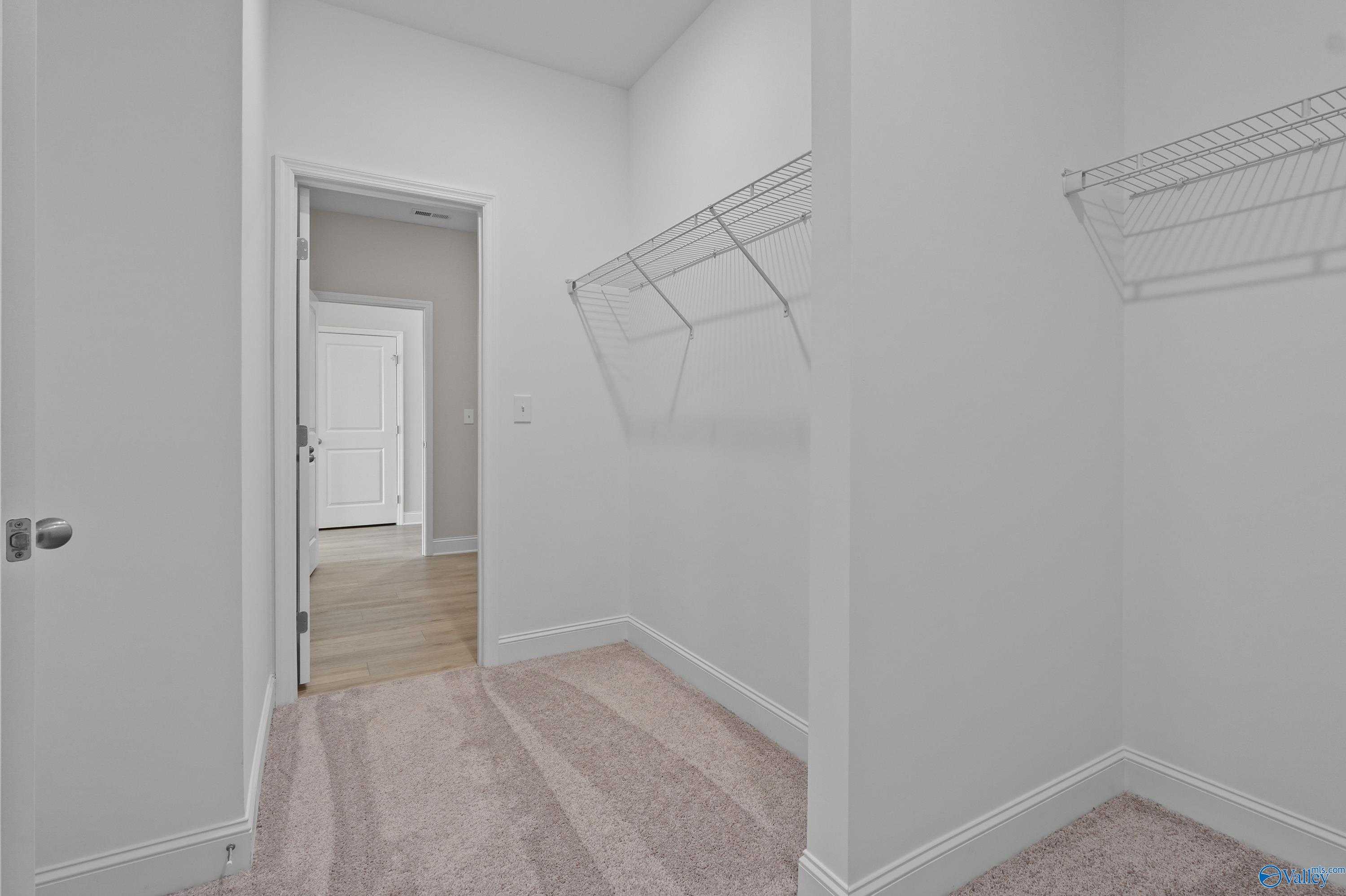 Spacious walk-in closet with wire shelving and open door to bedroom in Davidson Homes The Everett, Hazel Green, Alabama