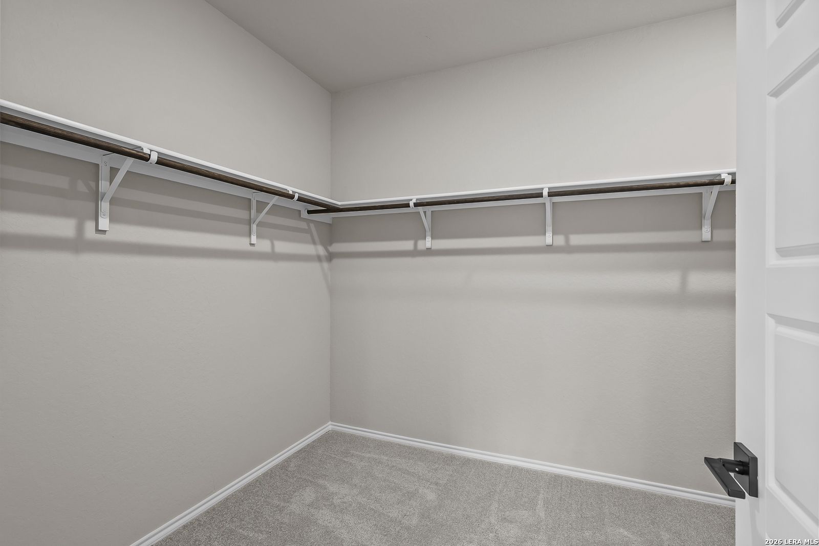 Spacious walk-in closet with wraparound hanging rods and shelving in Davidson Homes The Sequoia C, Royal Crest, San Antonio