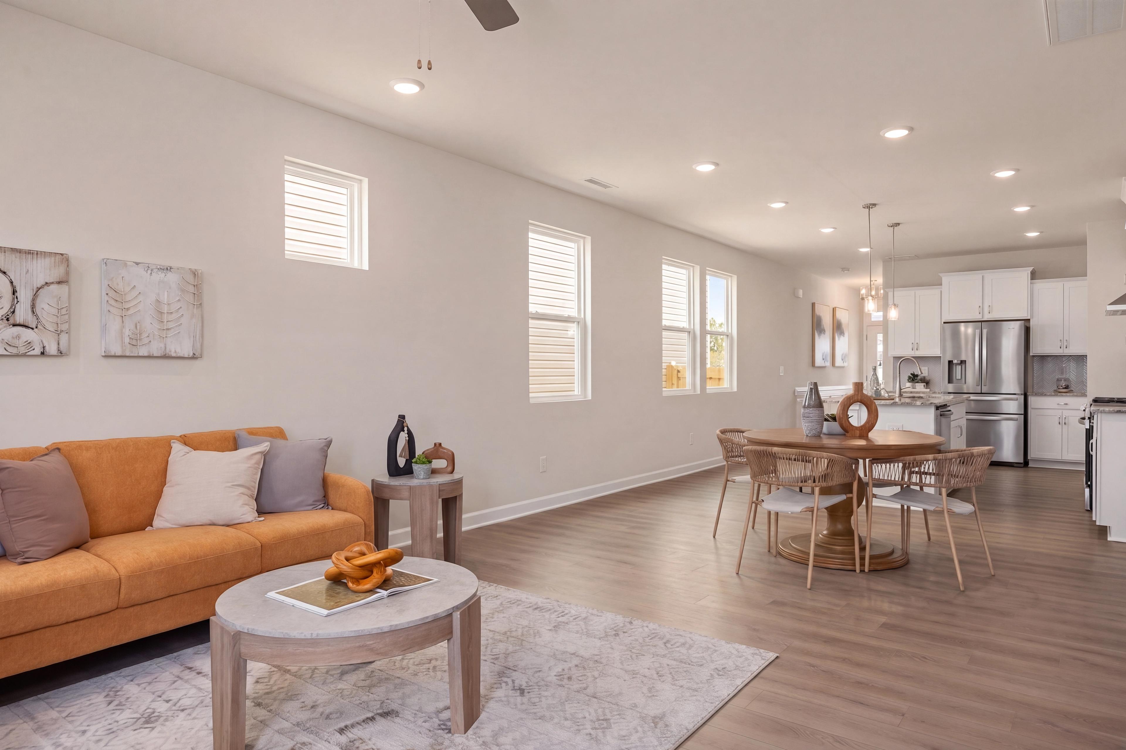 Open-concept living and dining area at Gregory Village in Lillington, NC, featuring a modern sofa and hardwood floors.