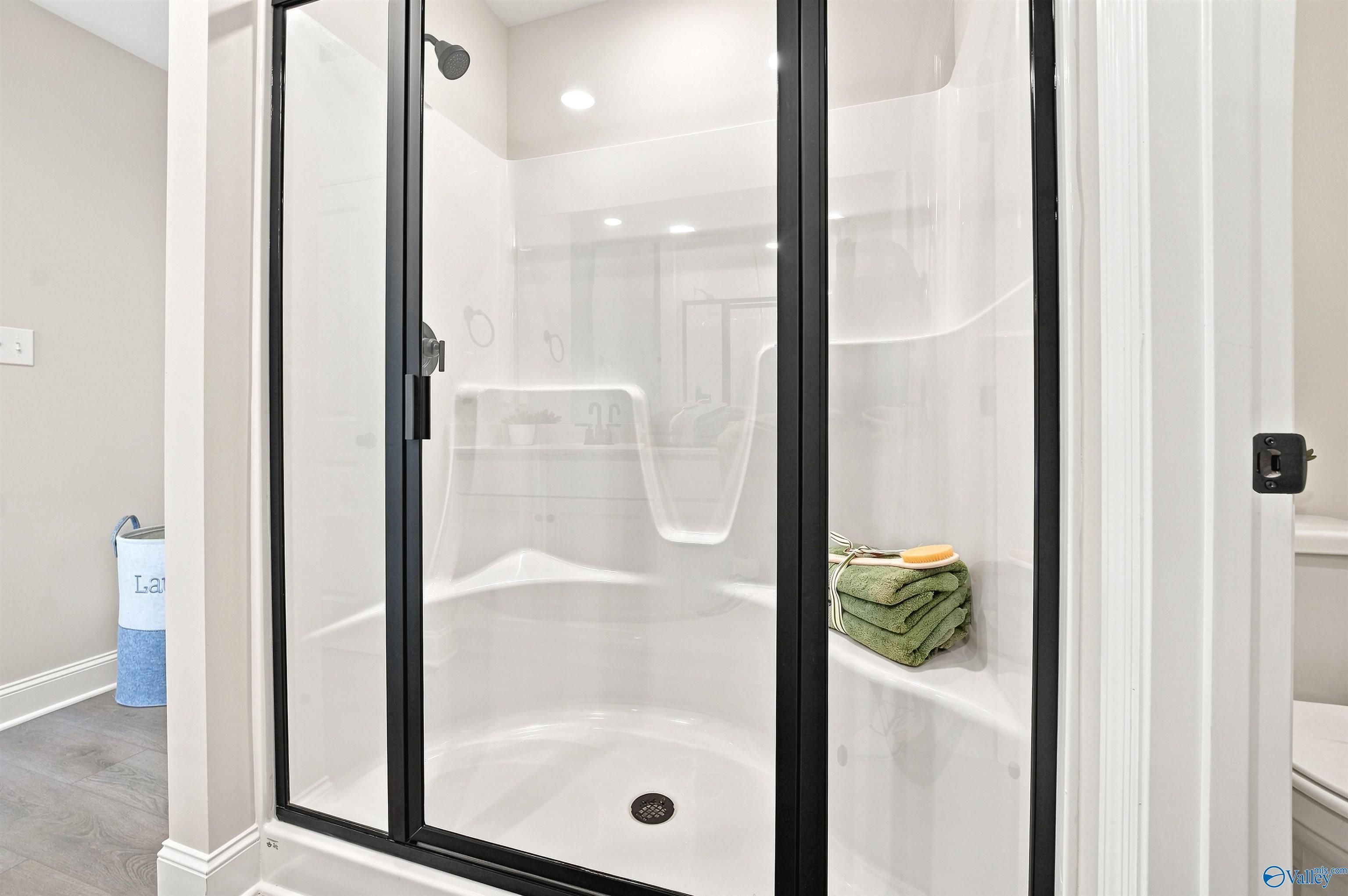 Modern walk-in shower with black frame in The Burton B floor plan at Heritage Lakes, New Market, Alabama.